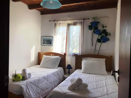 een slaapkamer met 2 bedden met witte lakens en een raam bij Quinta da Ti Júlia in Tomar