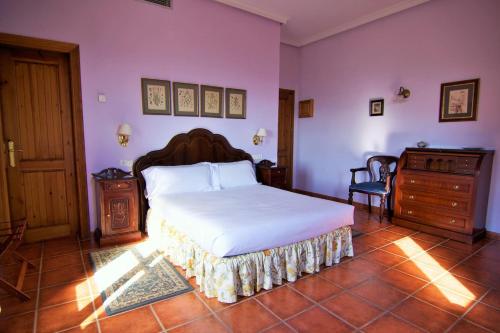 - une chambre avec un grand lit et des murs violets dans l'établissement Nuevespigas, à Casarabonela