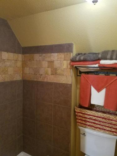 a bathroom with a shower and a toilet with towels at Cabin Sweet Cabin in Canyon Lake
