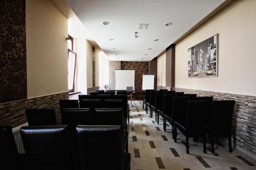 a dining room with black chairs and a brick wall at Hotel Viktória in Sárvár