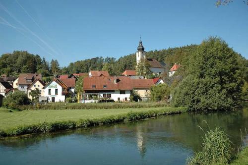 a town next to a river with a house at Limerhof in Waischenfeld