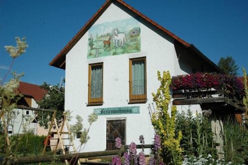 un bâtiment blanc avec une peinture de chevaux sur lui dans l'établissement Limerhof, à Waischenfeld