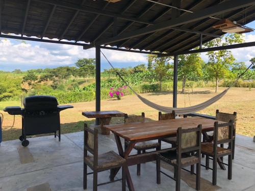a hammock and a table and chairs under a tent at Finca Hotel Brasilia in La Tebaida