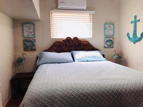 ein Schlafzimmer mit einem großen Bett mit einem hölzernen Kopfteil in der Unterkunft Condo de Cortez in Puerto Peñasco