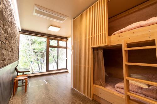 宮島にある宮島　ゲストハウス　三國屋の二段ベッドと窓が備わる客室です。