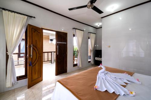 a bedroom with a bed with a dress on it at Megacahya Bungalow in Nusa Lembongan