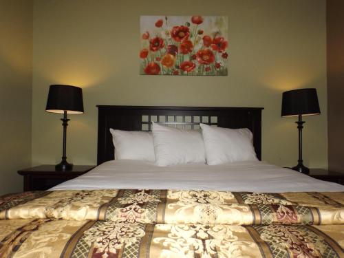 um quarto com uma cama grande e 2 candeeiros em The Villas on Lake George em Diamond Point