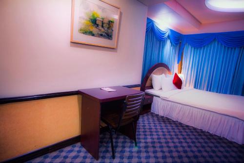 a hotel room with a desk and a bed and a deskictericter at Hotel 71 in Dhaka