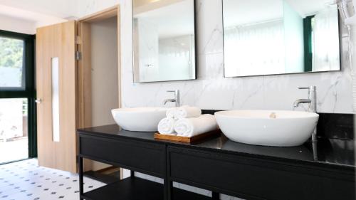 a bathroom with two sinks and two mirrors at Sea Passion Hotel in Koror