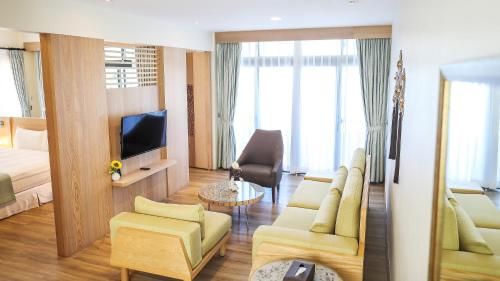 a living room with a bed and a tv in a room at Sea Passion Hotel in Koror