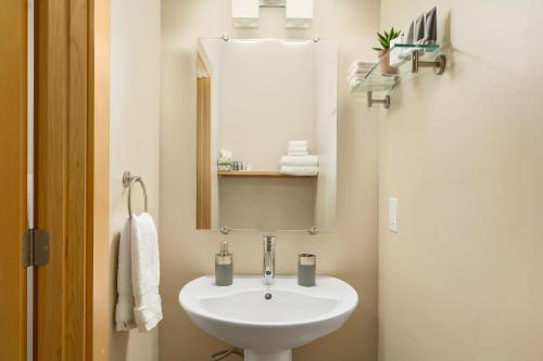 bagno con lavandino bianco e specchio di The Mountain Project #2 a Rossland