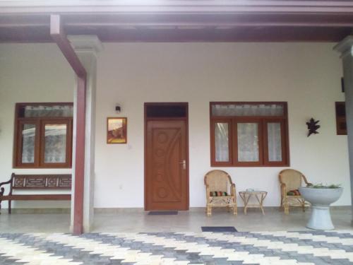 a room with two chairs and a wooden door at Orchid Dream in Bentota