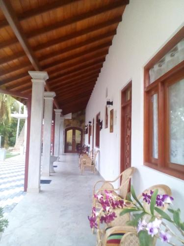 a porch of a building with benches and windows at Orchid Dream in Bentota