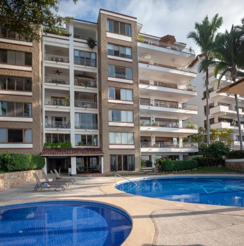 an apartment building with a swimming pool in front of it at Ocean Front, 3 bedroom, 3 bathroom, Casa Natalia, Playa Esmeralda in Puerto Vallarta