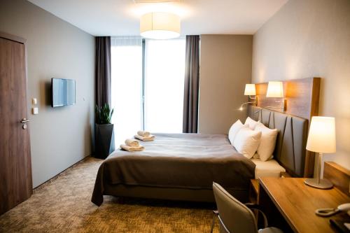 ジェシュフにあるAPART HOTEL 12のベッドとデスクが備わるホテルルームです。
