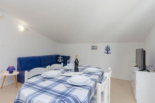 a dining room with a table and a tv at Apartments Snjezana in Pirovac