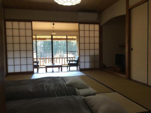由布市にある山荘 紗羅樹 Syaranokiのベッド付きの客室で、パティオの景色を望めます。