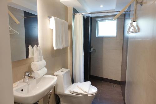 a bathroom with a toilet and a sink and a shower at Patio Pacific Resort in Boracay