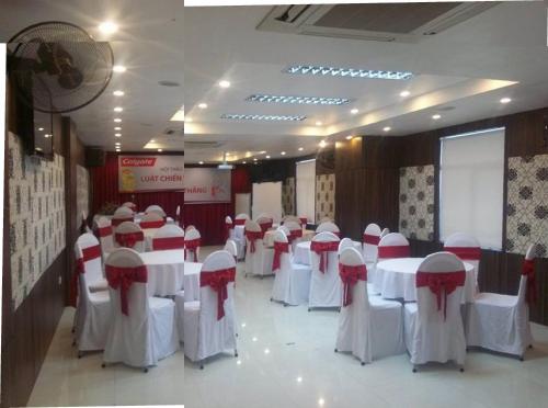 a banquet hall with white tables and red and white chairs at Van Mieu 2 Hotel in Hanoi