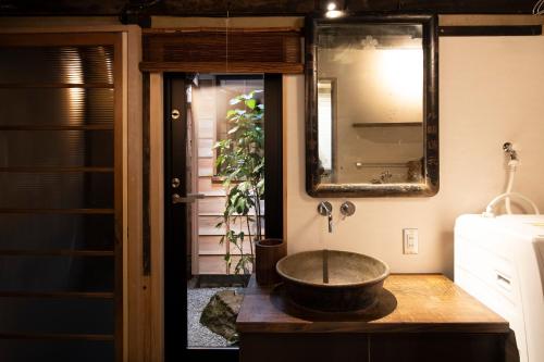 bagno con lavabo a ciotola e specchio di Kanazawa Machiya Kenroku a Kanazawa