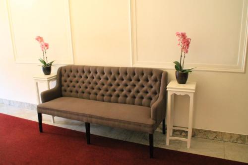 a brown couch sitting in a room with two tables at De Doelen in Leiden