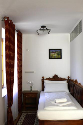 a small bedroom with a bed with white sheets at Hotel Viktoria in Meersburg