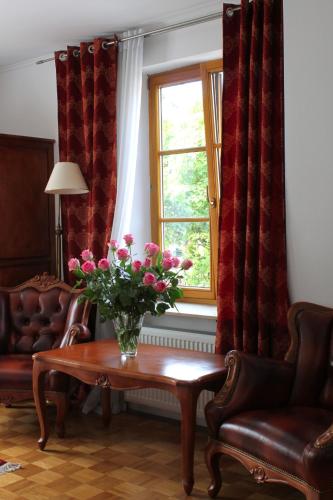 a living room with a vase of flowers on a table at Hotel Viktoria in Meersburg