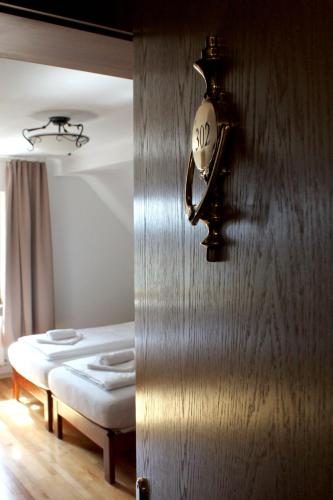 a clock hanging on a wall next to a bed at Hotel Viktoria in Meersburg