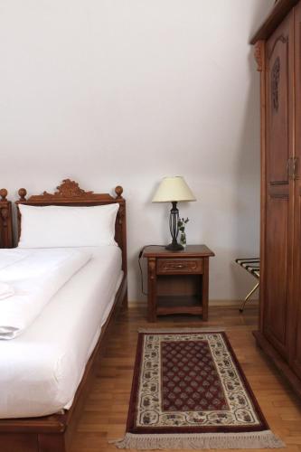 a bedroom with a bed and a table with a lamp at Hotel Viktoria in Meersburg