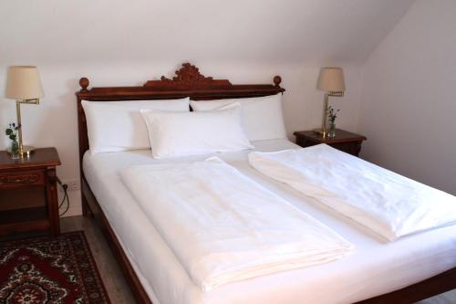 a large white bed with two pillows on it at Hotel Viktoria in Meersburg