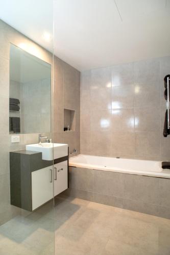 a bathroom with a sink and a bath tub at Tea House Motor Inn in Bendigo