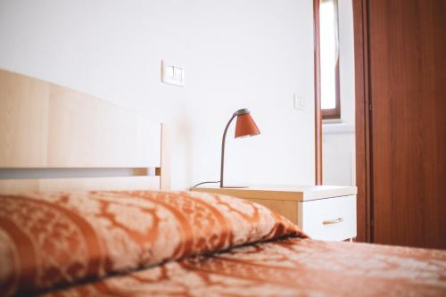 a bedroom with a bed and a lamp on a night stand at Hotel Ristorante Mira Conero in Porto Recanati