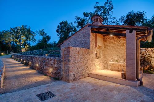 an outdoor pavilion with lights on a stone wall at Relais La Costa Historical Residence in Monteriggioni