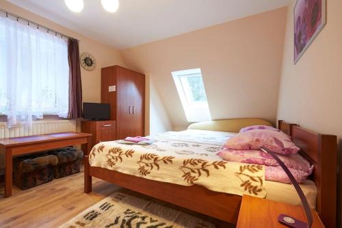 Habitación pequeña con cama y escritorio. en Pokoje Gościnne Venus en Szklarska Poręba