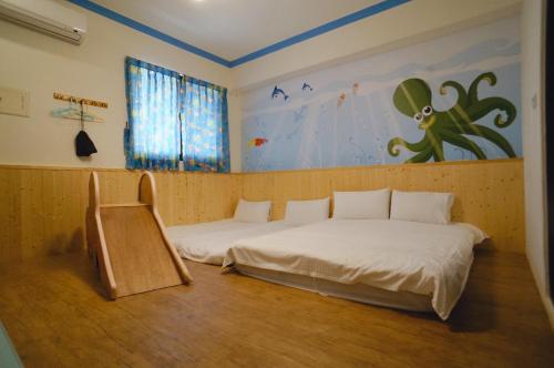 a room with two beds and a painting on the wall at Childlike Innocence Homestay in Ji'an