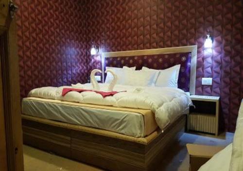 a bedroom with a bed with two swans on it at Wooden Nest Cottage Hunder, Nubra Valley in Nubra