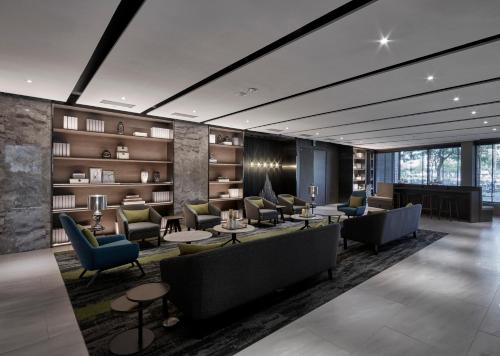 a lobby with couches and tables and books at Harbour 10 Hotel in Kaohsiung