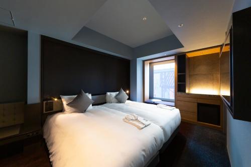 a large white bed in a room with a window at The Royal Park Canvas - Ginza 8 in Tokyo
