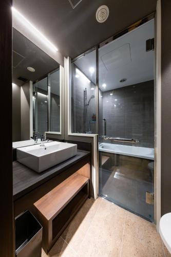 a bathroom with a large white sink and a tub at The Royal Park Canvas - Ginza 8 in Tokyo