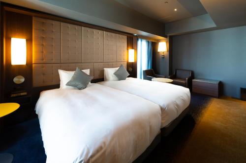 a large white bed in a hotel room at The Royal Park Canvas - Ginza 8 in Tokyo