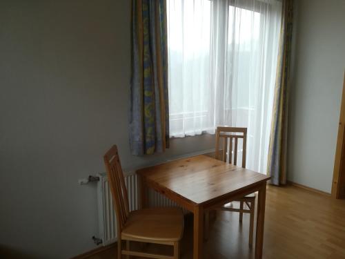 een houten tafel en stoelen in een kamer met een raam bij Sinsamreith, Familie Ensmann in Göstling an der Ybbs
