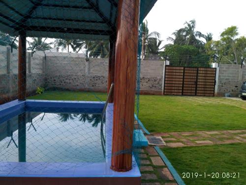 a tennis court with a net and a fence at Waves Beach House in Puducherry