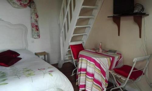 1 dormitorio con 1 cama y 1 mesa con sillas en domaine du mont scolan, en Montgardon