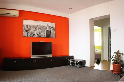 ヤシにあるApartament Copouのオレンジ色の壁のリビングルーム(薄型テレビ付)
