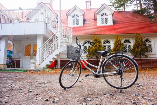 a bike parked in front of a house at Karuizawa Pension Sato no Nukumori in Karuizawa