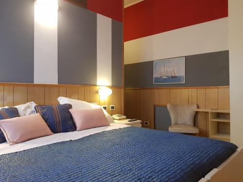 a bedroom with a large bed with pink and blue pillows at Hotel Azzurra in Salsomaggiore Terme