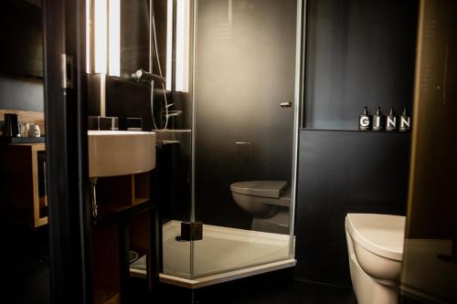 a bathroom with a glass shower and a toilet at GINN Hotel Hamburg Elbspeicher in Hamburg