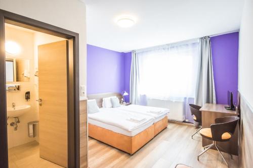 ein Hotelzimmer mit einem Bett und einem Bad in der Unterkunft Hotel Turmfalke in Linz
