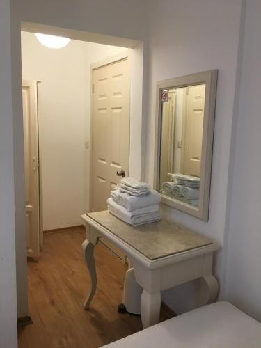 a bathroom with a table and a mirror at Bodrum Sade Otel in Bodrum City