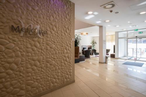 a lobby with a wall in the middle of a building at Hotel Mercure Graz City in Graz